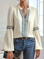 Notched textured balloon-sleeve blouse in cream striped front view with hands together