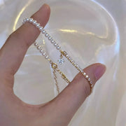 Pearl bracelet draped across fingers to show its chain and charm