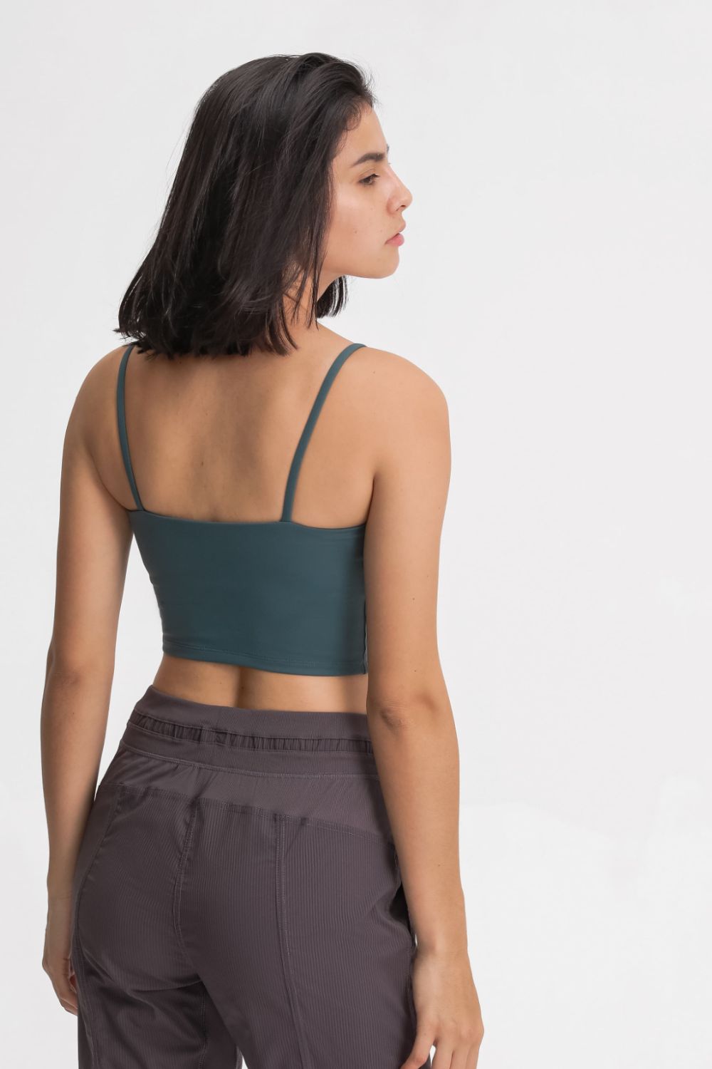 Back view of a model wearing a teal cami with thin straps.