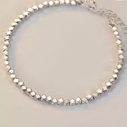 Faceted geometric links arranged in a silver bracelet with extension chain