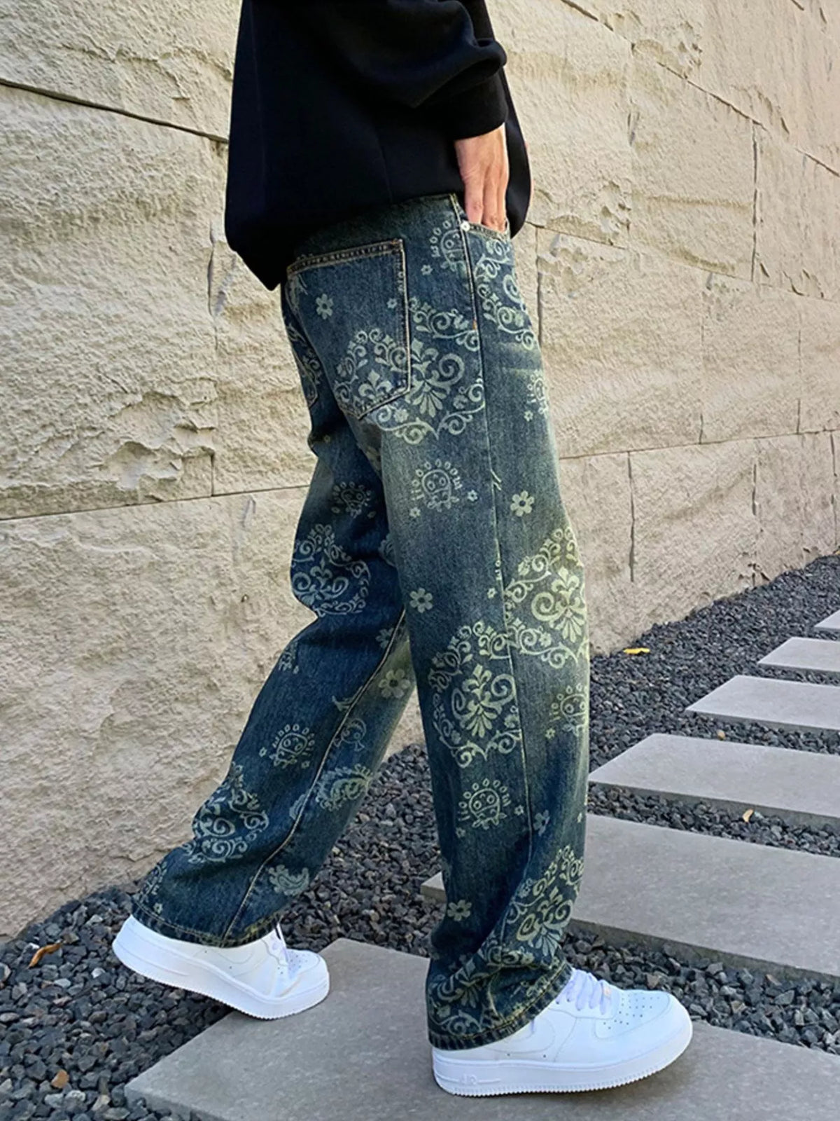 Rear side view of patterned blue jeans showing the loose leg shape
