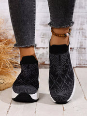Front view of black slip-on mesh trainers with white sculpted soles