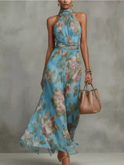 Model wearing a blue floral sleeveless maxi dress with a flowing skirt.