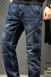 Close-up of the faded front and contrast-stitched panels on dark blue jeans