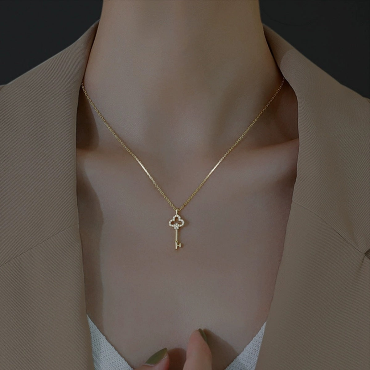 Model wearing key pendant necklace over a light top