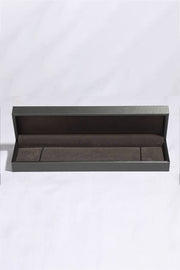 Silver bracelet displayed in an open dark presentation box.