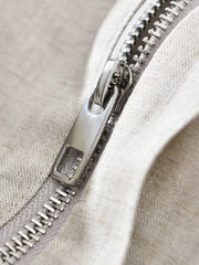 Close view of metal zipper on light neutral jacket