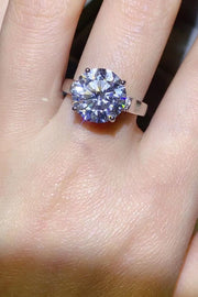 Large round moissanite solitaire ring worn on a hand, viewed from above.