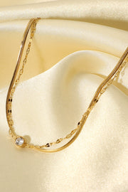 Close view of the fine gold-tone chains and rhinestone detail