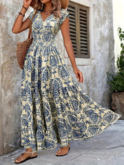 Purple floral cap-sleeve maxi dress shown front-on with a fitted smocked waist.