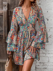 Model wearing colorful paisley V-neck mini dress with bell sleeves, front view