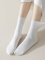Pair of plain white mid-calf socks displayed on feet