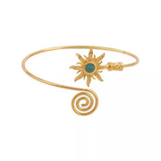 Open gold-tone cuff bracelet with turquoise sunburst centerpiece and spiral end