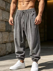 Grey loose-fit corduroy joggers with cuffed ankles shown from the front