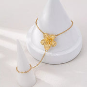 Gold-tone flower hand chain bracelet displayed on jewelry stand