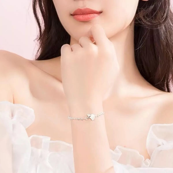 Silver ginkgo leaf bracelet worn on a wrist in a lifestyle photo