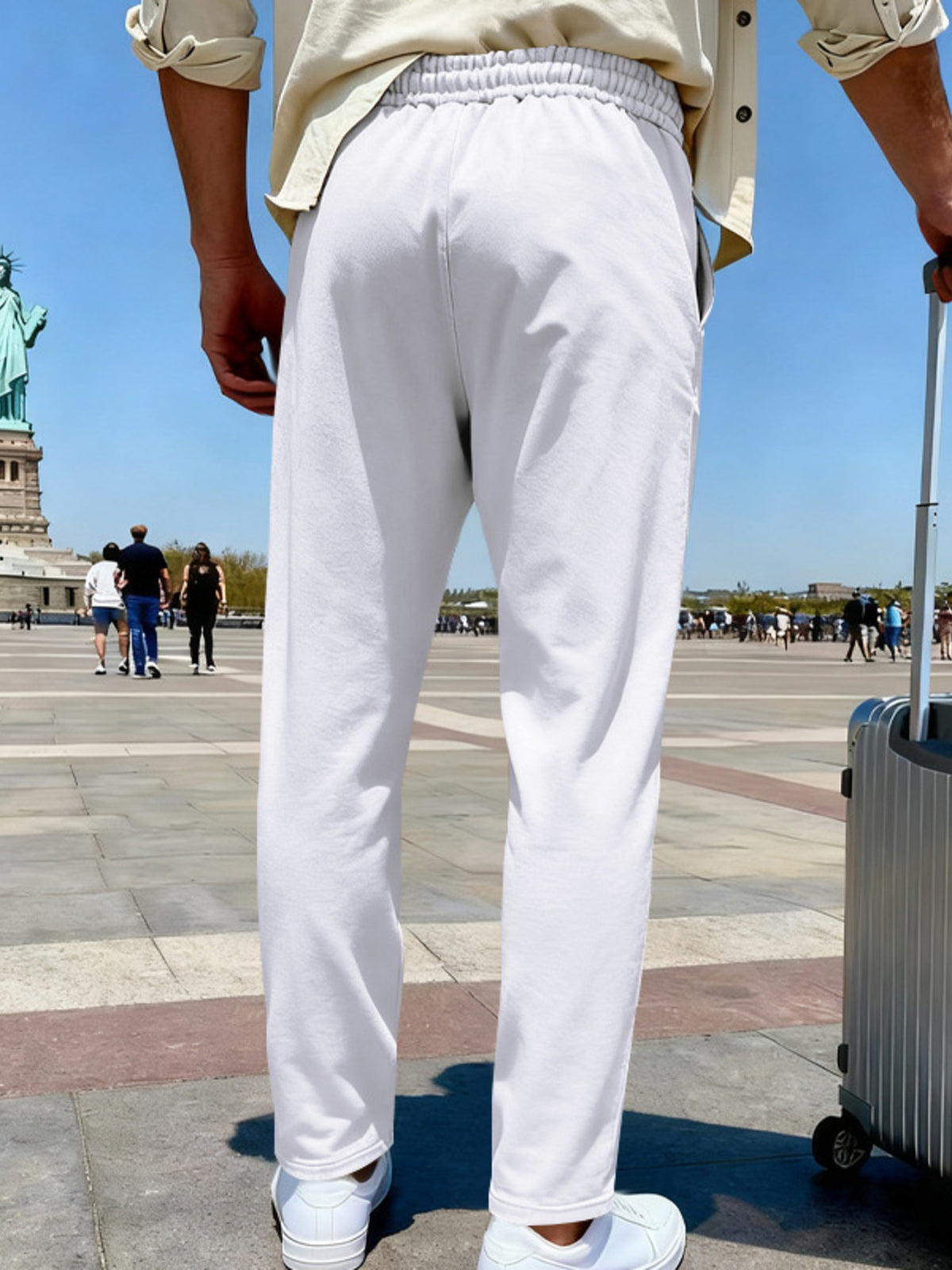 Back view of white wide-leg pants with an elastic waistband in a Paris plaza.
