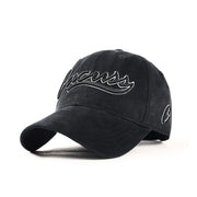 Washed black baseball cap with outlined cursive embroidery and curved brim, front angled view