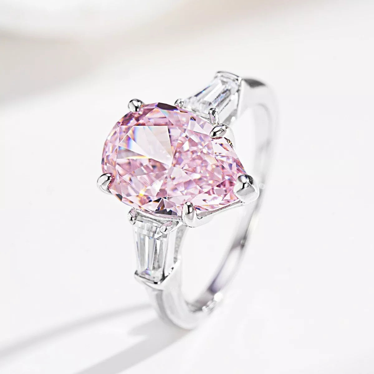 Angled view of the pink center stone ring and its tapered clear side stones.