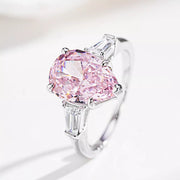 Angled view of the pink center stone ring and its tapered clear side stones.