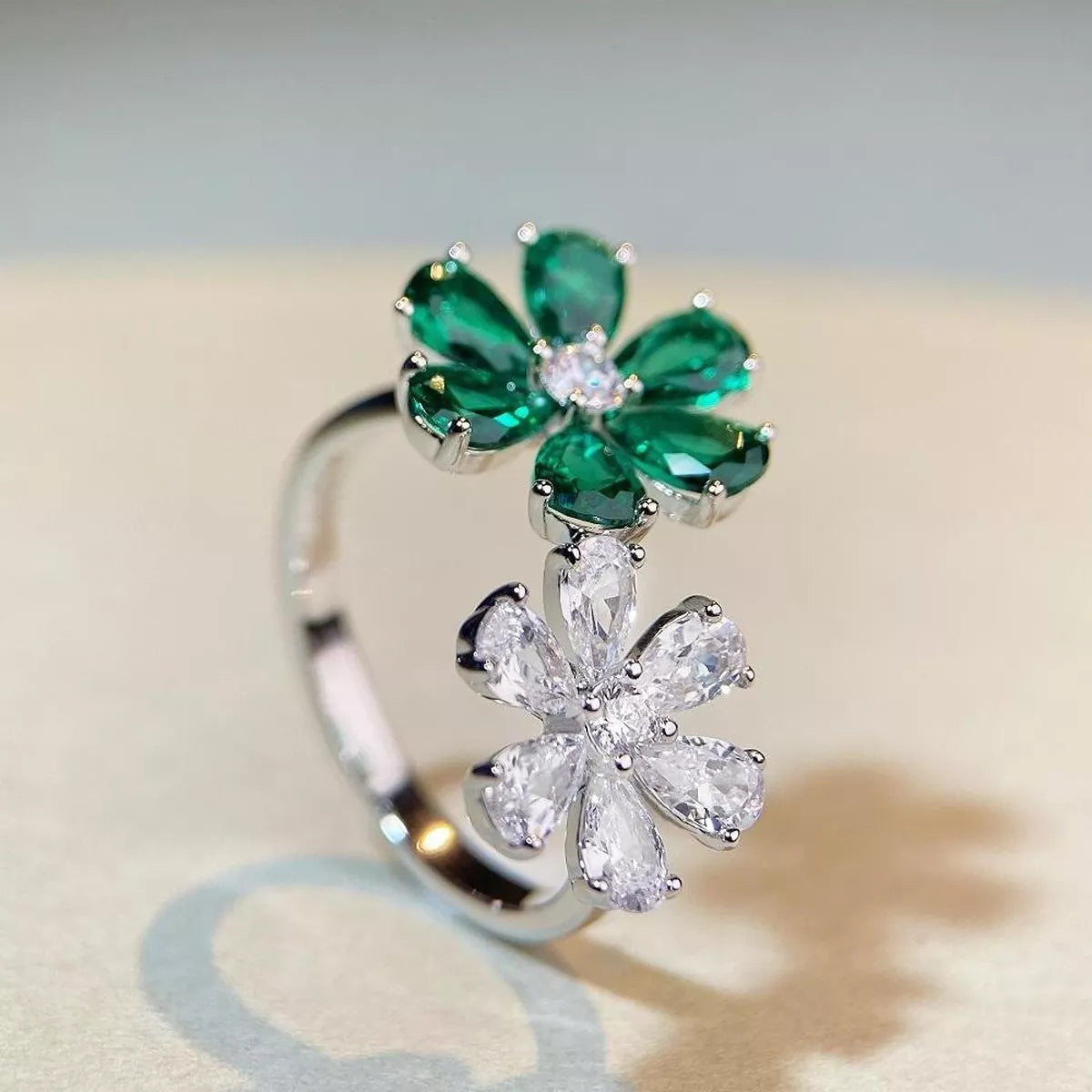 Front angle showing the green jeweled flower above the clear flower on the ring
