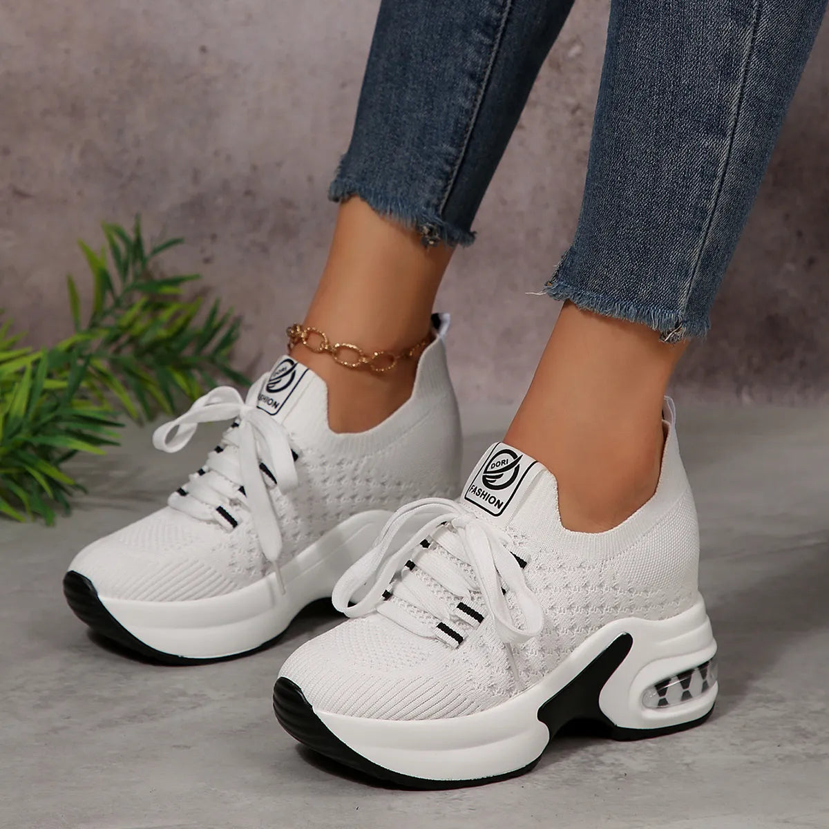 White lace-up platform sneakers worn with jeans, side view of raised sole