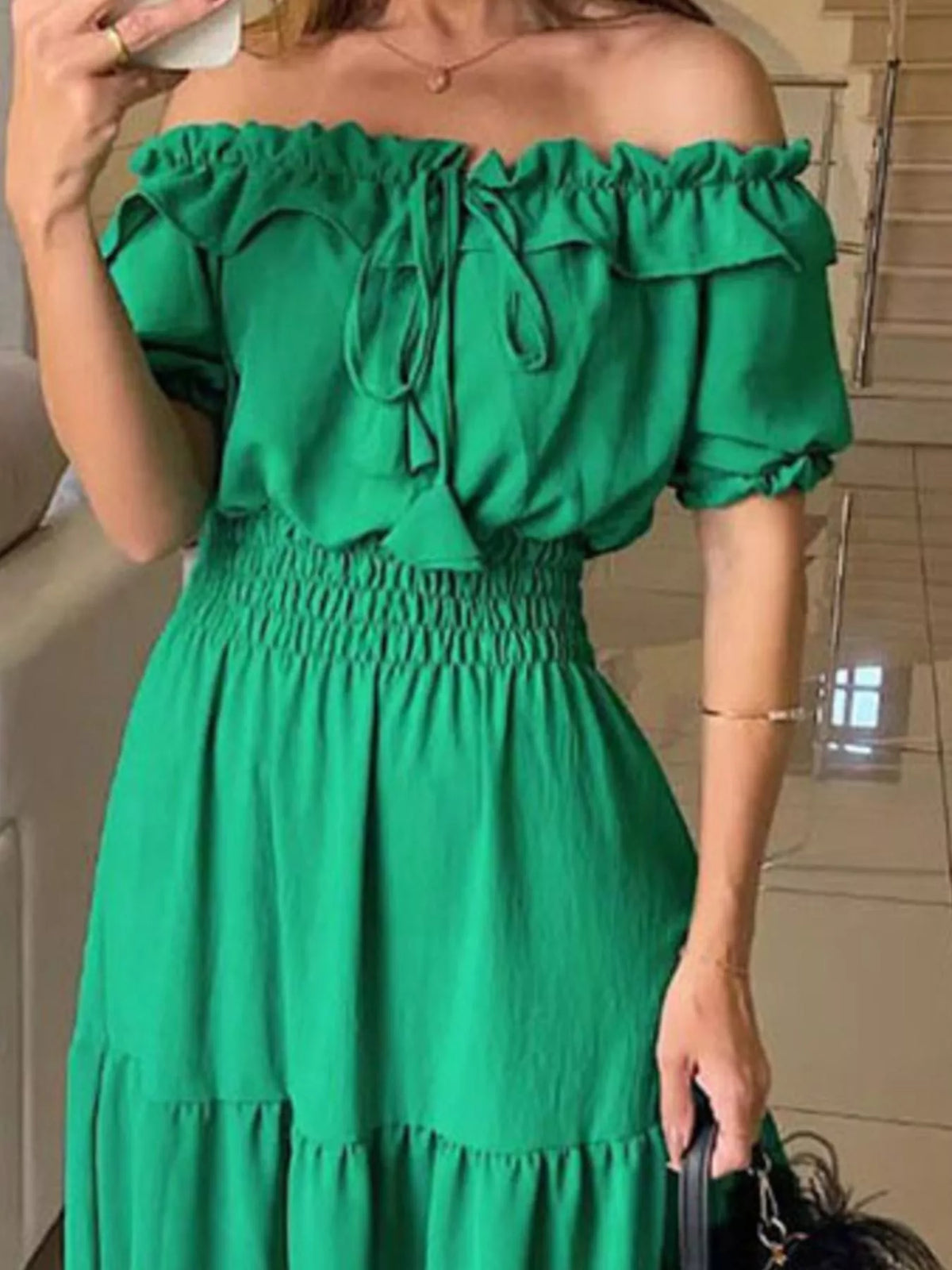 Close view of green maxi dress showing off-shoulder ruffles and smocked waist