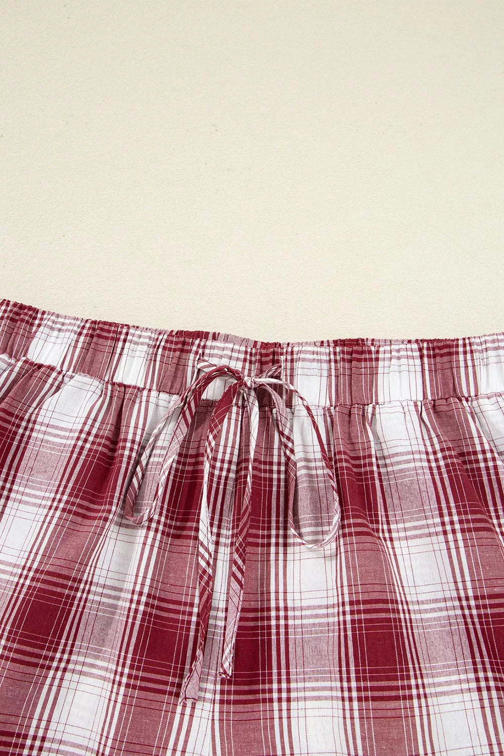 Red plaid pajama shirt and drawstring shorts shown from behind