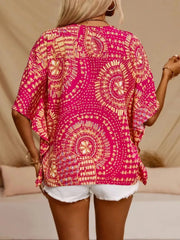 Back view of a pink and yellow medallion-print blouse with loose half sleeves.
