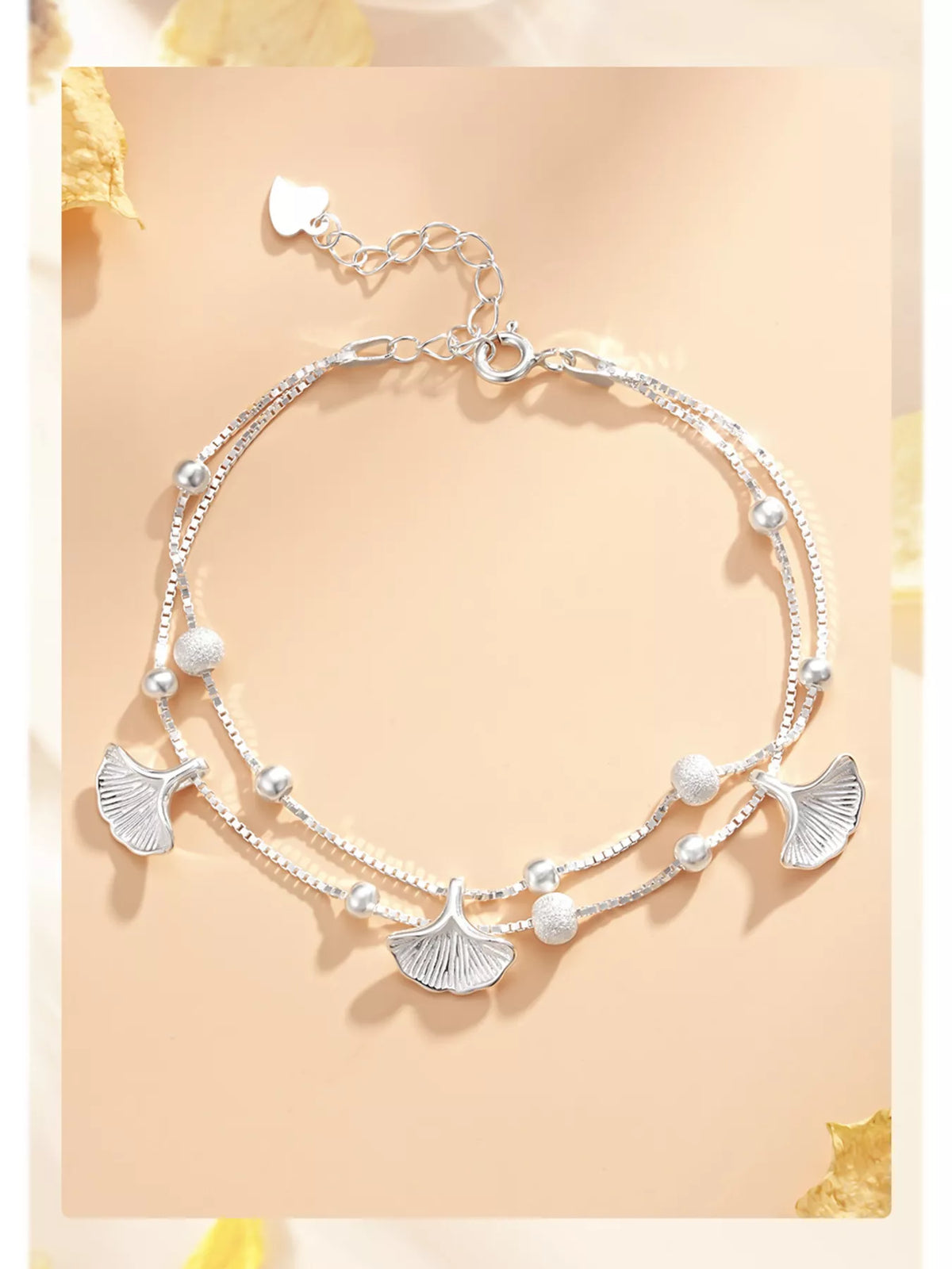 Double-layer ginkgo leaf bracelet shown laid out with its extension chain