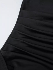 Close-up of the black dress's gathered ruching and textured fabric.