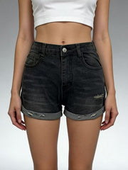 Front view of black roll-up denim shorts on model