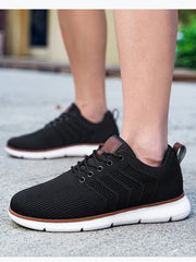 Black lace-up knit shoes with white segmented soles and brown trim, worn outdoors