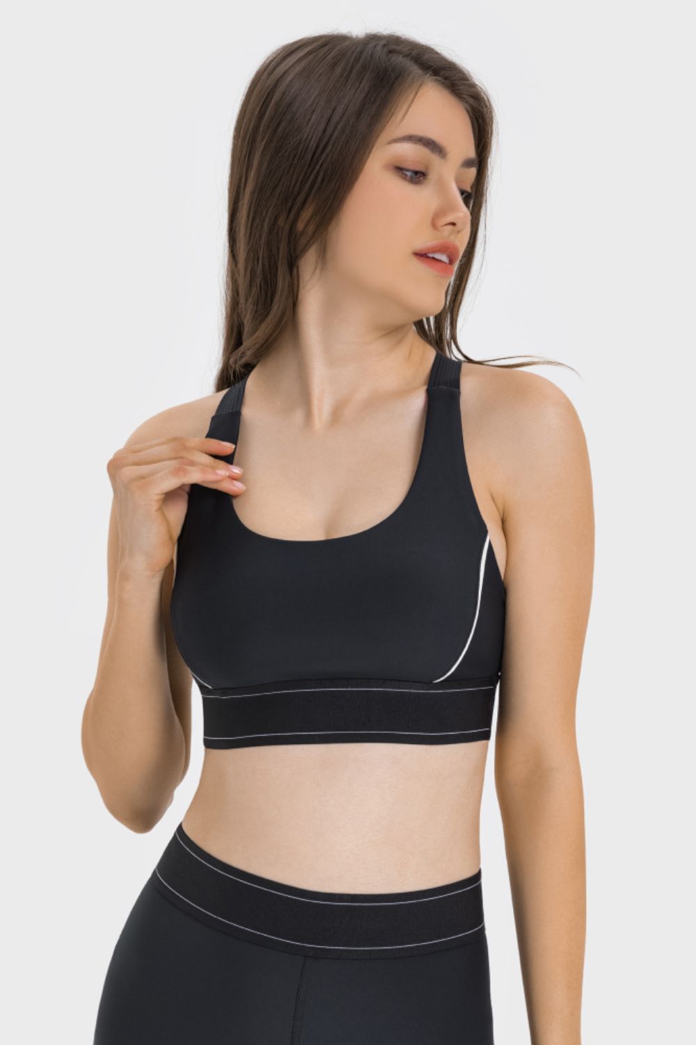 Model wearing a black contrast sports bra, angled front view