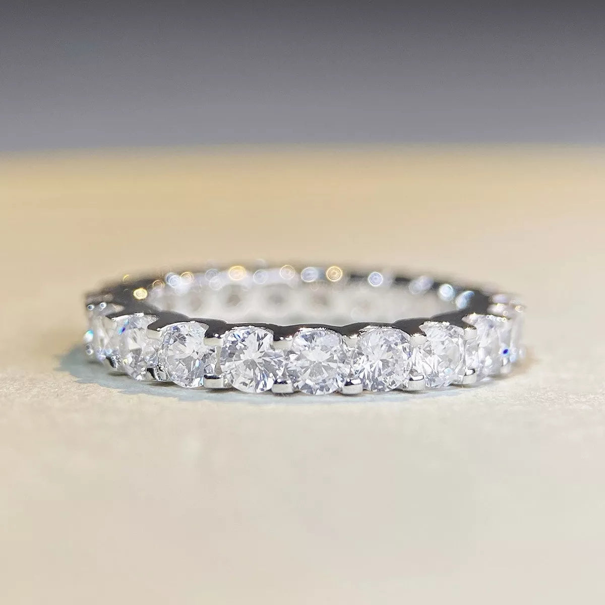 Side profile of a silver ring showing the raised pink center stone and slender band.