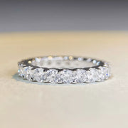 Side profile of a silver ring showing the raised pink center stone and slender band.