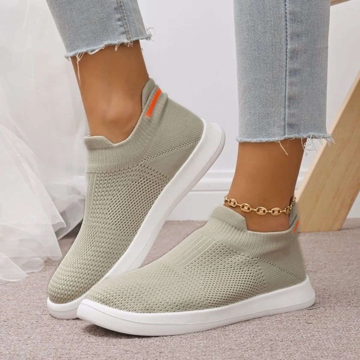 Sage green mesh slip-on sneakers worn with jeans