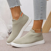 Sage green mesh slip-on sneakers worn with jeans