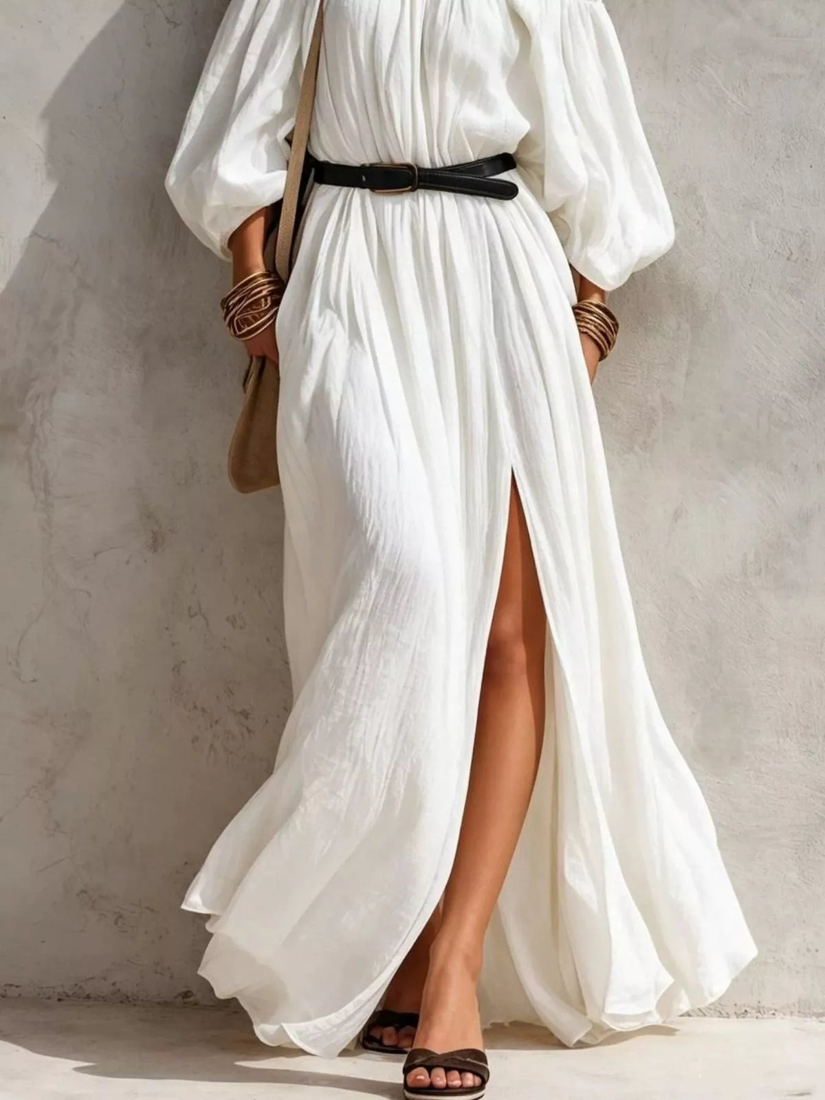 Full-length white off-shoulder maxi dress with black belt and front side slit