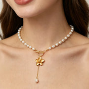 Close view of pearl beads and gold flower pendant on the choker necklace