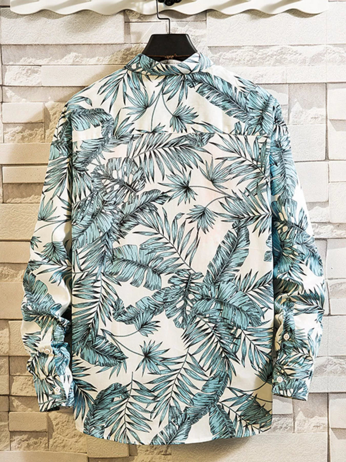 Back view of a white shirt with blue-green tropical leaf print