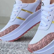 Close-up of pink patterned panels and gold trim on sneakers