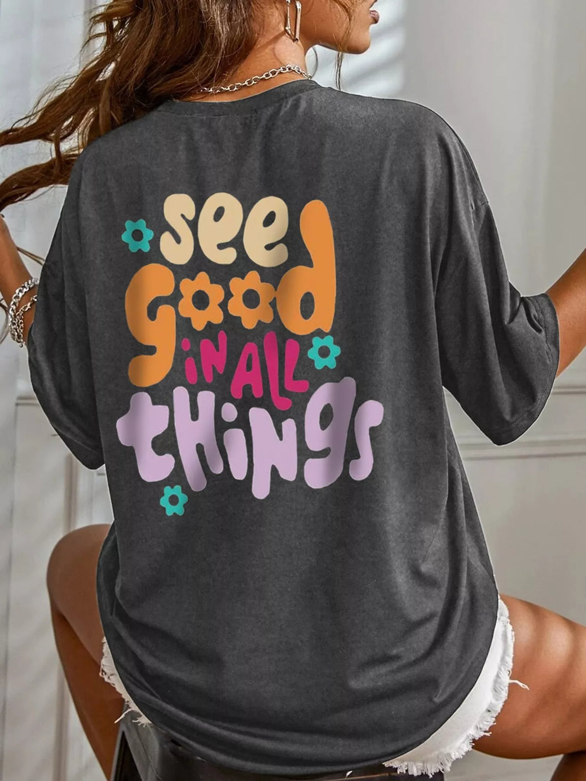 Back view of the dark gray oversized T-shirt with colorful lettering and flower graphics