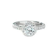 Front view of a round clear center stone ring with a halo and pavé shoulders