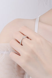 Slim half-eternity ring worn on a hand, shown close up.