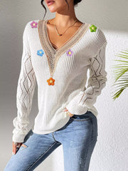 Angled view of the white sweater with a hand in the jeans pocket.