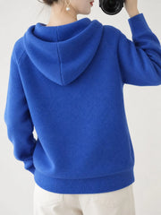Back view of the royal blue knit sweater showing its hood and ribbed hem.