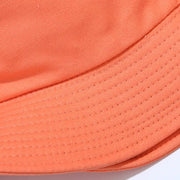 Close view of orange bucket hat brim with rows of stitching