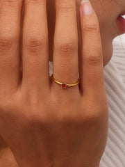 Gold-tone ring with blue stone shown on hand