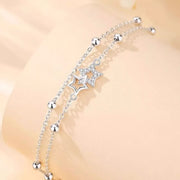 Close-up of two dangling star charms and beads on the silver bracelet